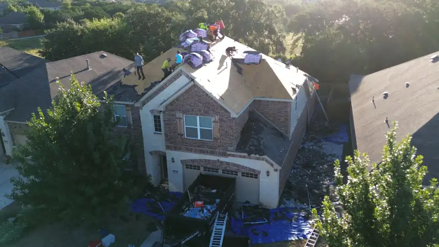 Crew installing a new roof by DNA Restoration & Construction