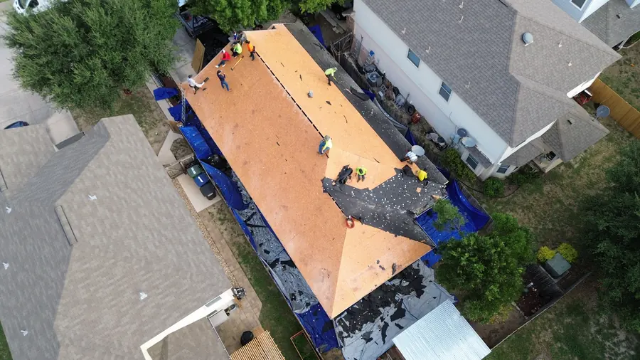 Drone photo of tarps protecting the side yard and walkway during a roof replacement